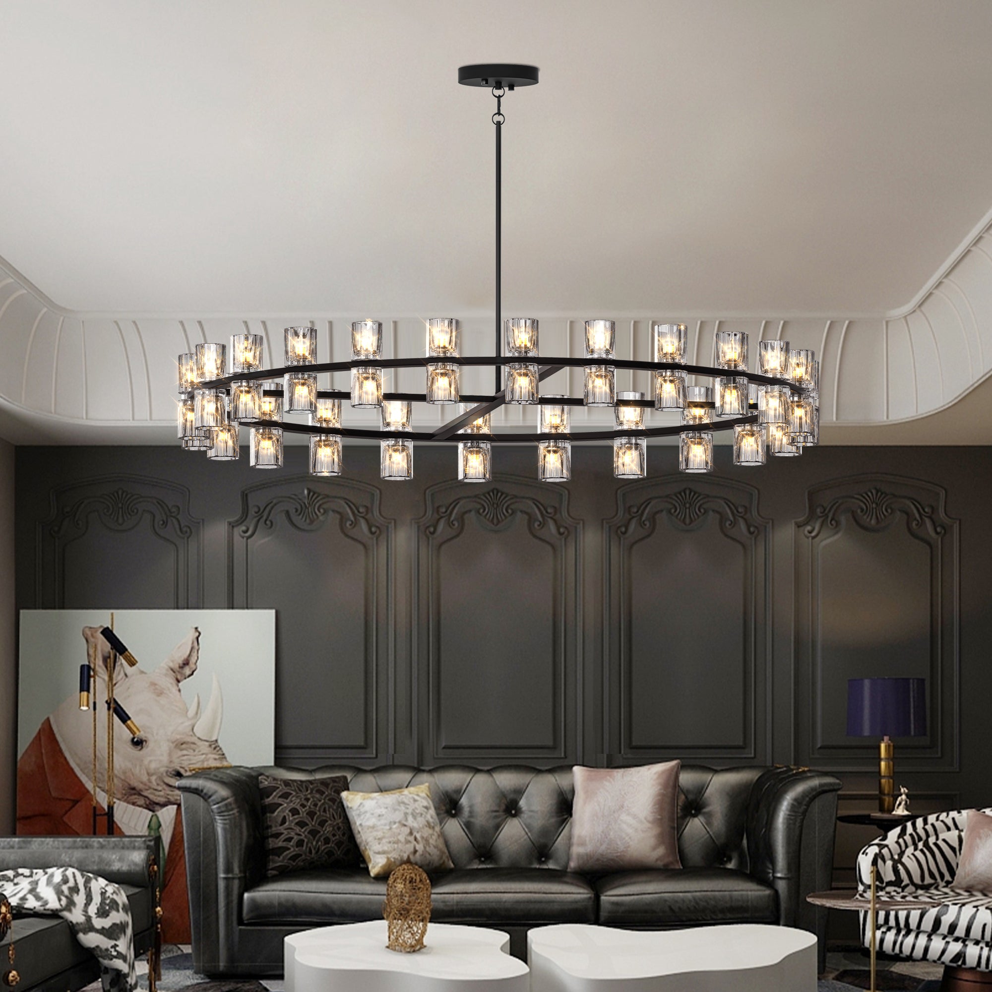 Modern chandelier hanging above a living room with dark paneled walls and a gray sofa.
