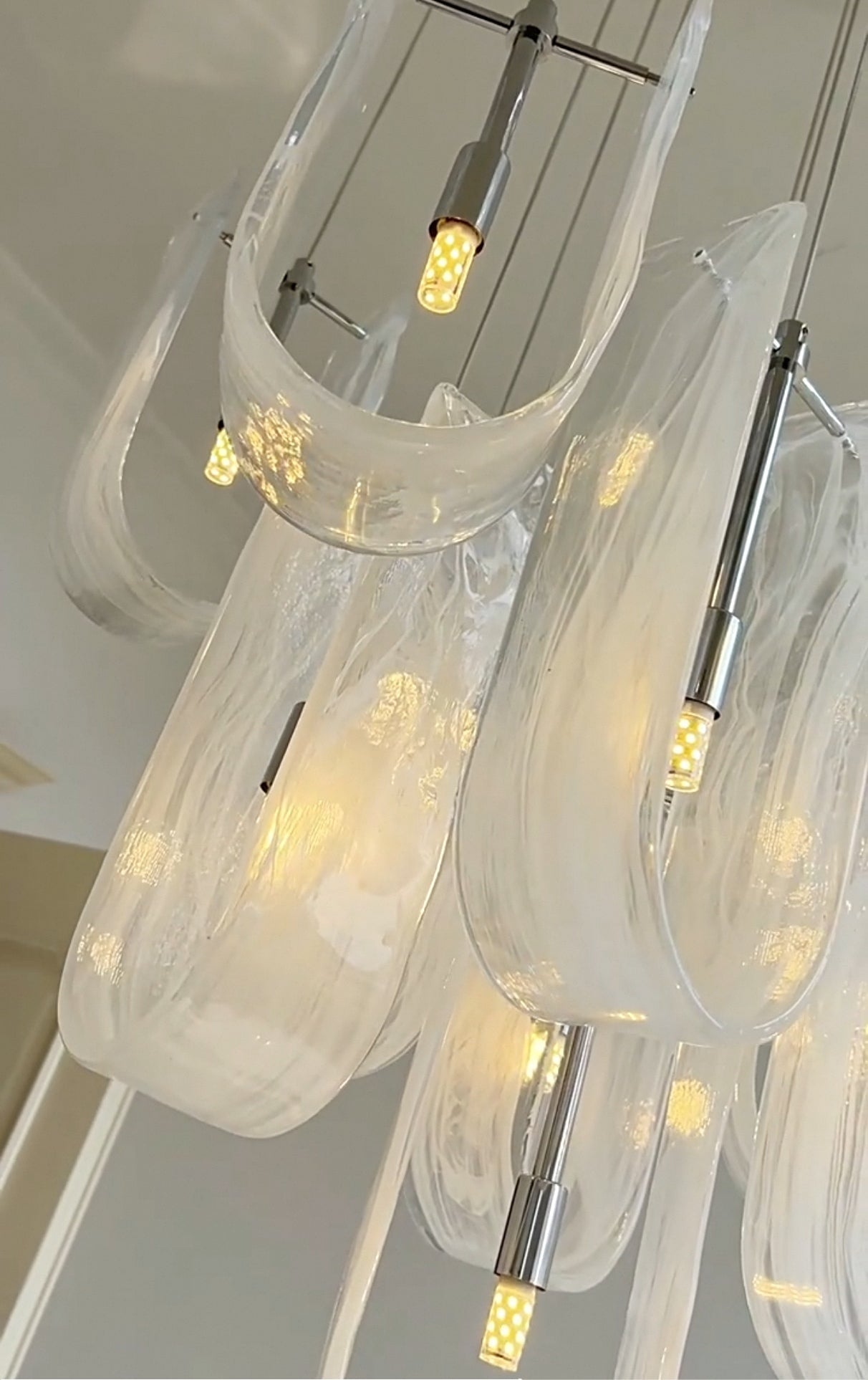 Artistic upward view of the Luminous Waves chandelier, highlighting its sculptural quality.