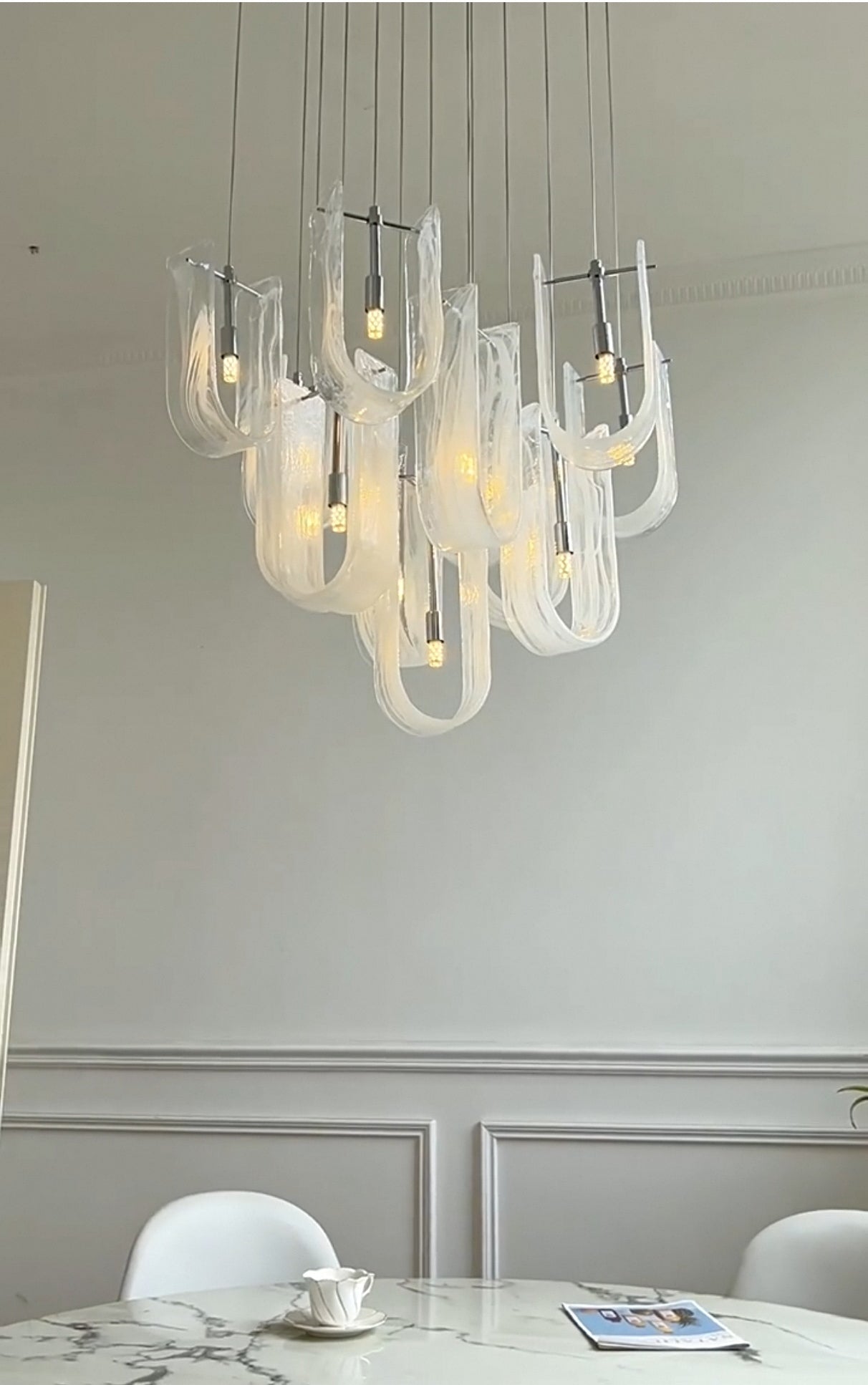 Side profile view of the Luminous Waves LED chandelier, emphasizing its elongated and graceful form.
