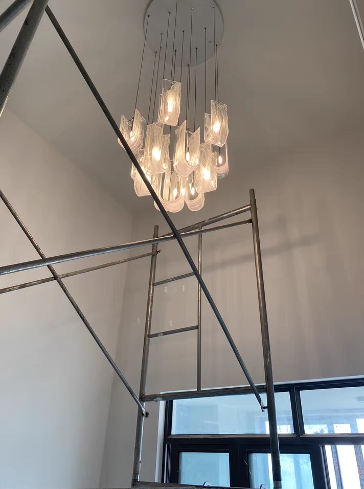 Grand Luminous Waves Chandelier by Aurorae Lighting suspended in a spacious foyer with high ceilings, making a luxurious statement.