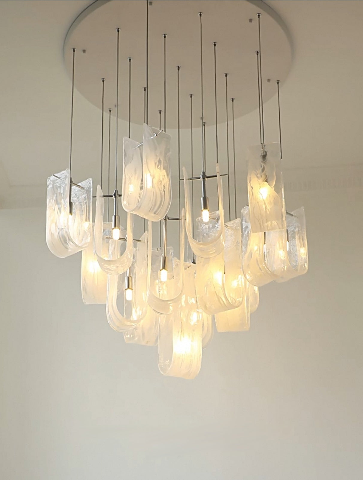 Close-up view of the Luminous Waves chandelier's integrated LED lights and unique wave design.