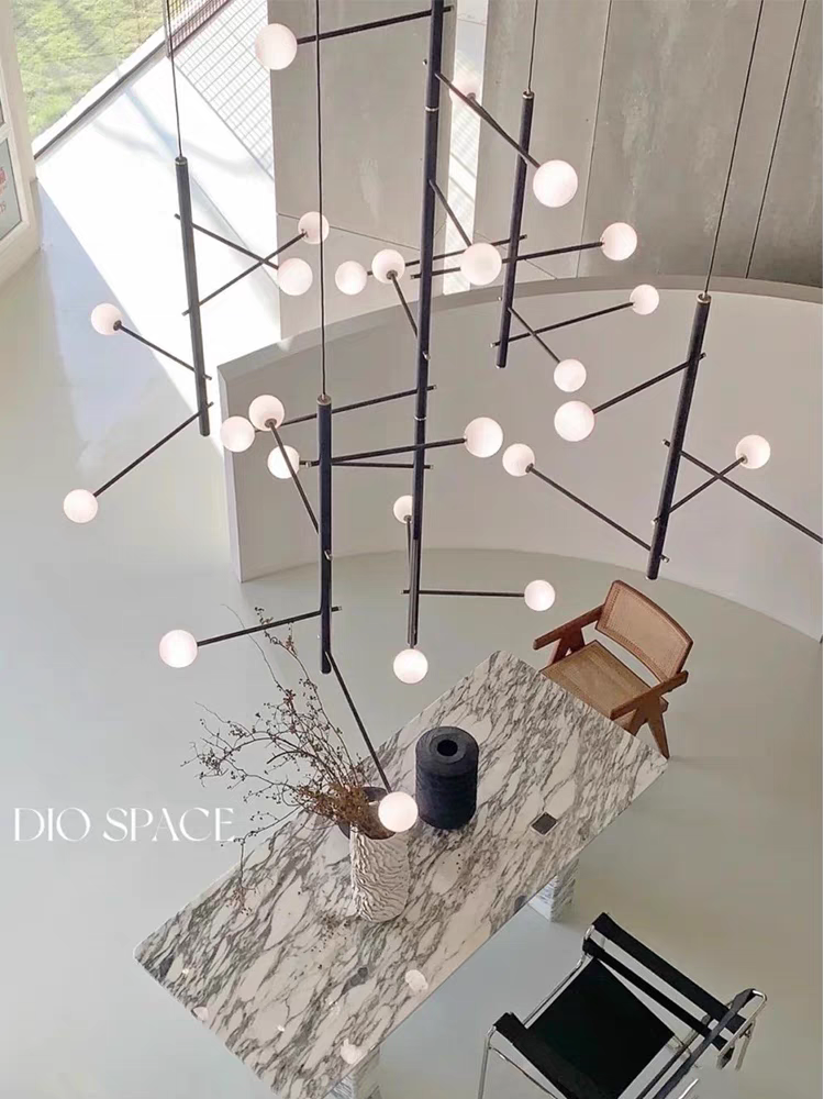 Black multi-arm opal glass chandelier in a stylish living room viewed from above, highlighting its warm glow.