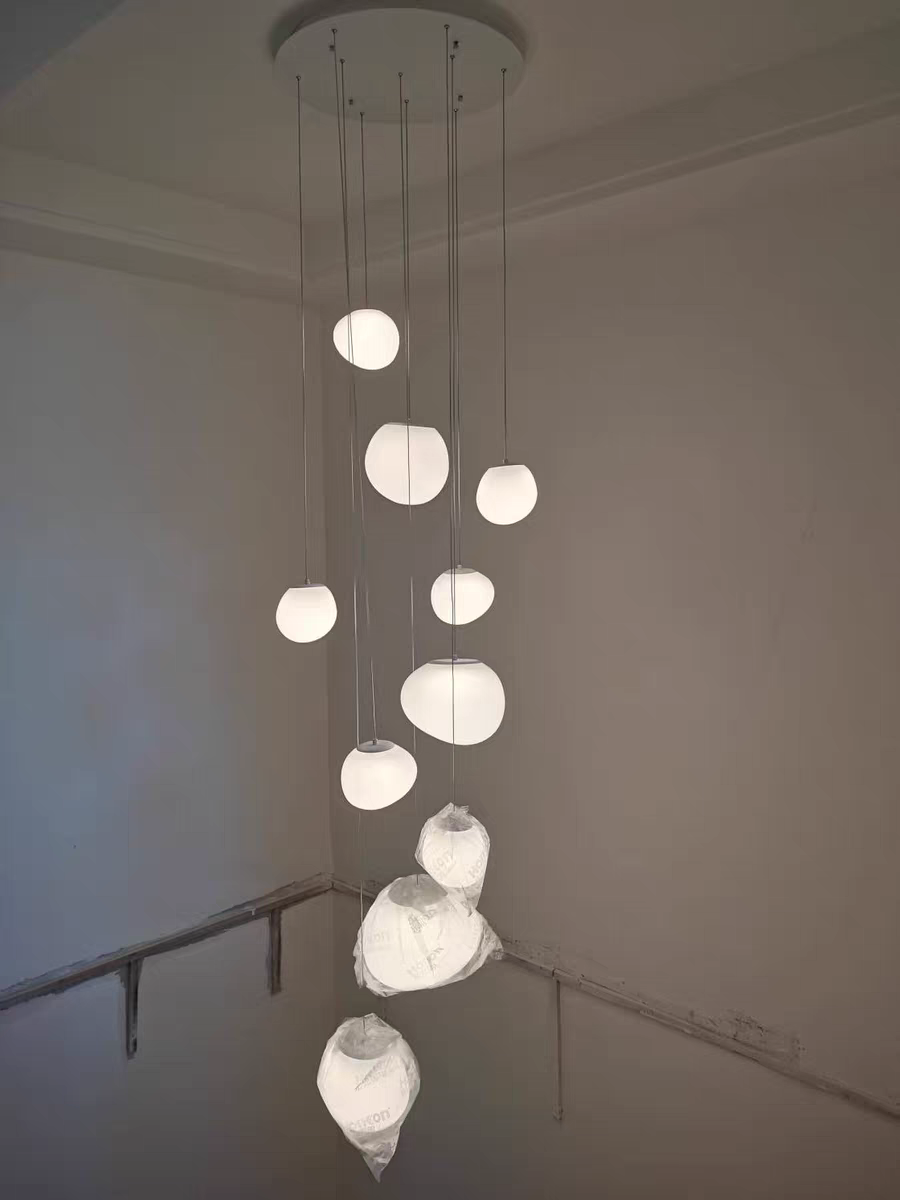 Aurorae Lighting Pebbles pendant light shown against a dark wall for contrast