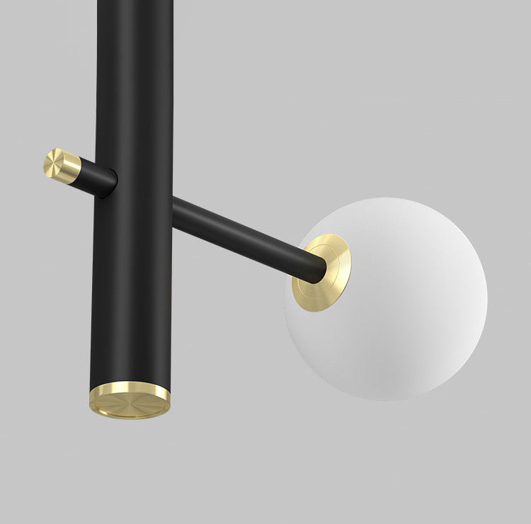 Close-up detail of the black arms and white opal glass globes on the chandelier.