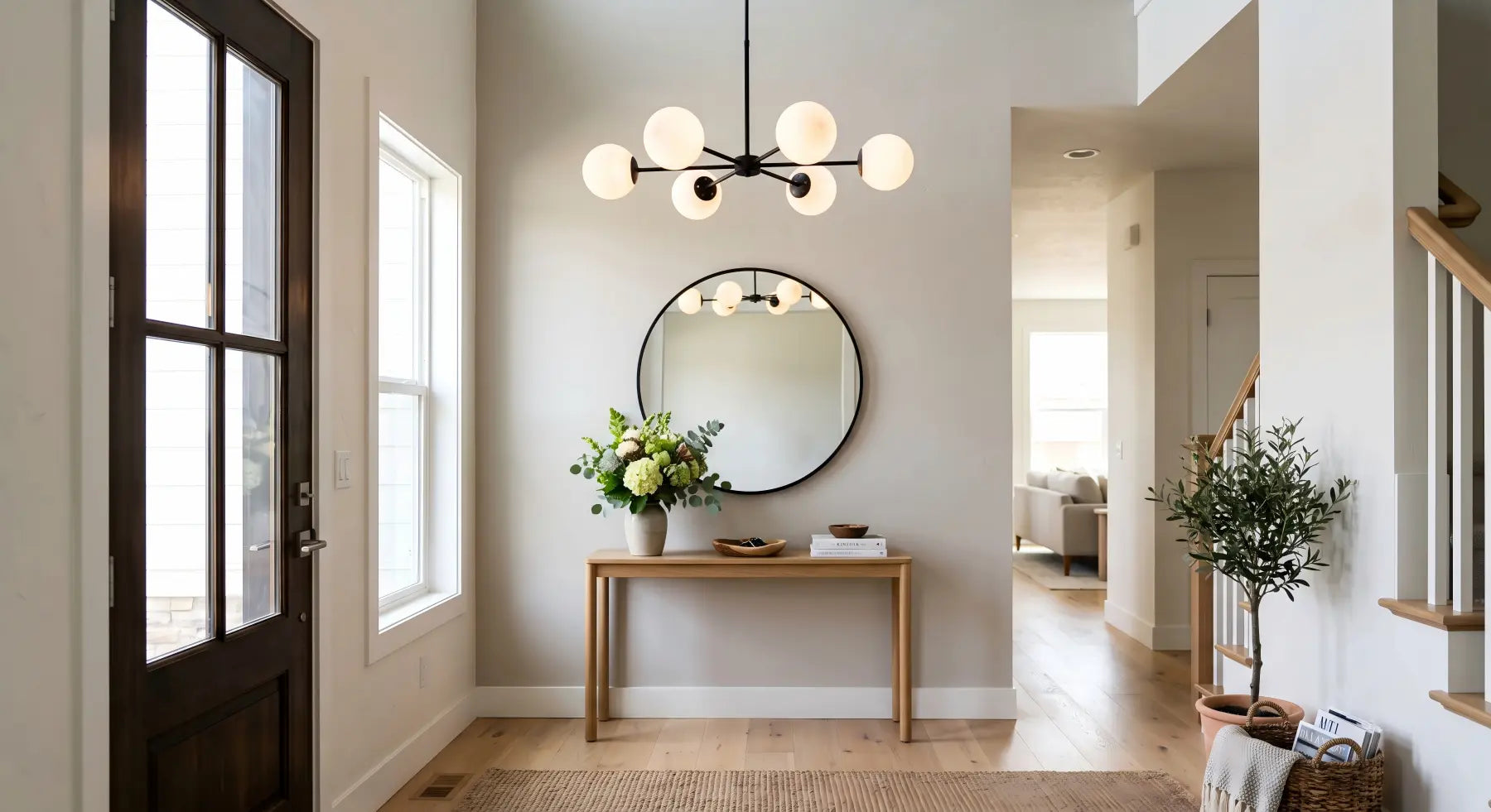 Modern glass globe chandelier in a staged home entryway creating a warm first impression