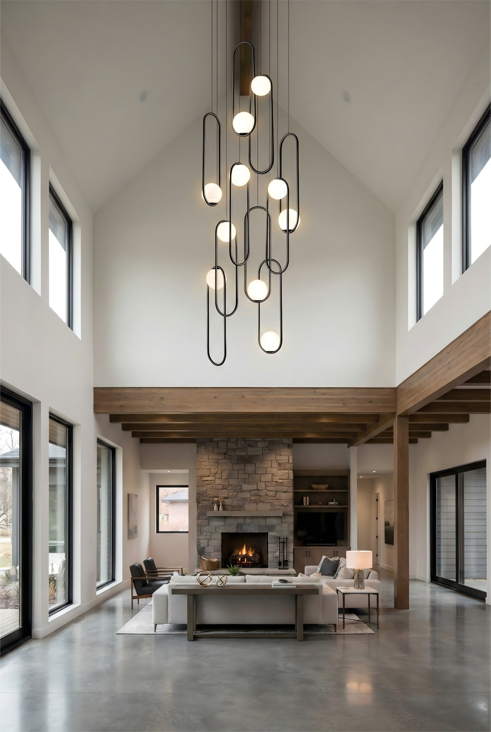 Modern living room with a large chandelier, fireplace, and large windows.